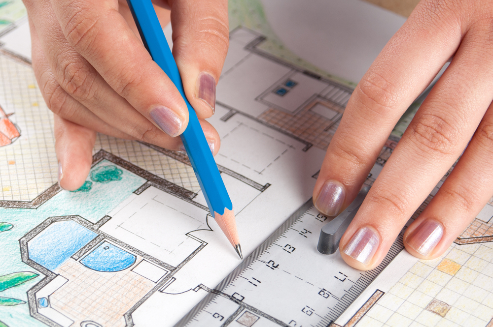 Someone drawing a blueprint of a house.